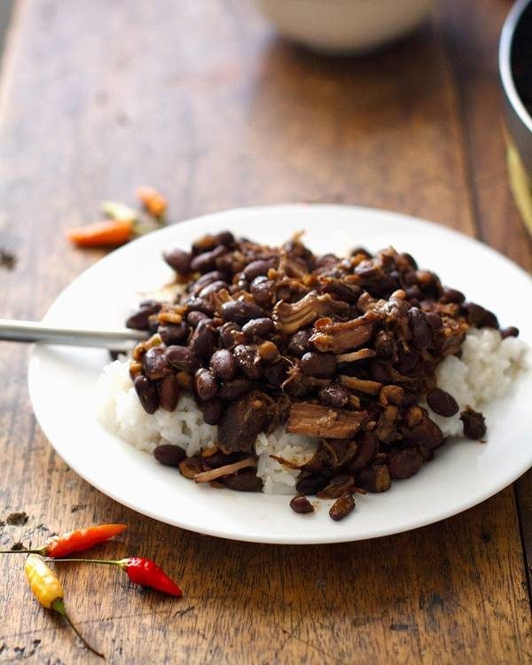 Crockpot pork adobo with black beans on a white plate.