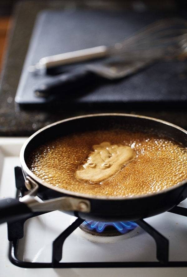 Liquid boiling in a skillet on the stove.
