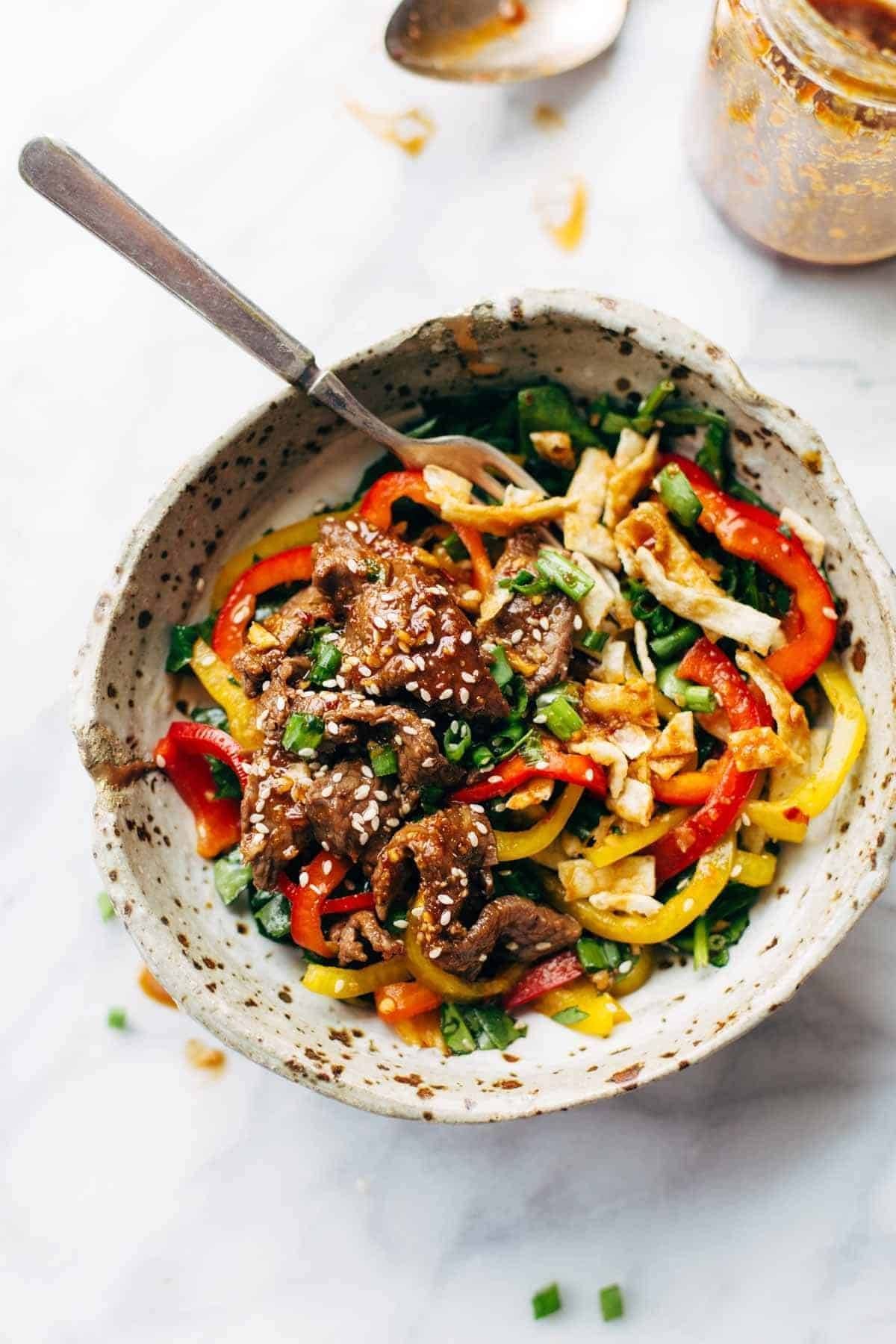Korean BBQ Steak Bowls! Featuring Korean BBQ steak, bell peppers, scallions, greens, wonton strips, a spicy sesame ginger dressing. | pinchofyum.com Korean BBQ Steak Bowls! Featuring Korean BBQ steak, bell peppers, scallions, greens, wonton strips, a spicy sesame ginger dressing. | pinchofyum.com