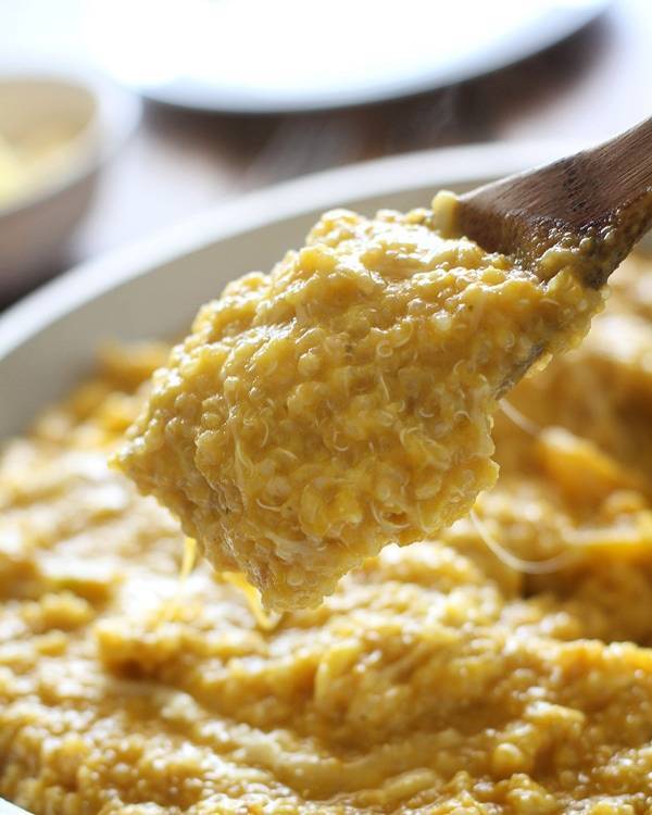 Squash curry quinoa in a bowl and on a wooden spoon.