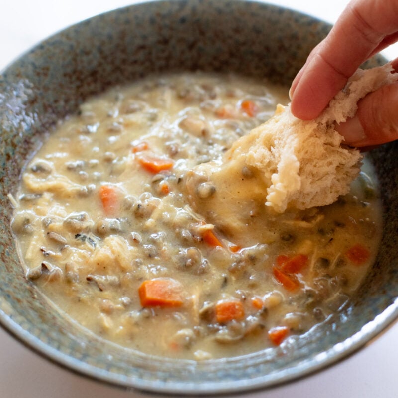 Crockpot Chicken Wild Rice Soup in a bowl with bread dip