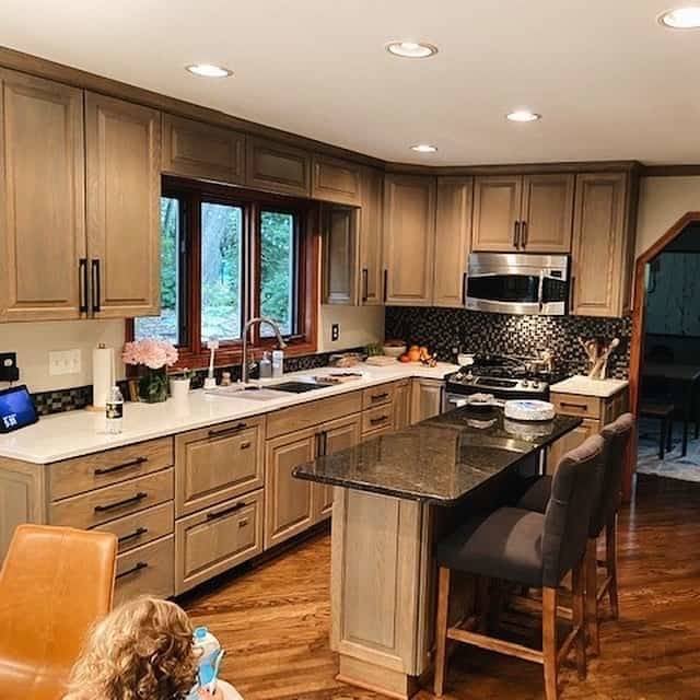 A child walking into the main part of a kitchen.