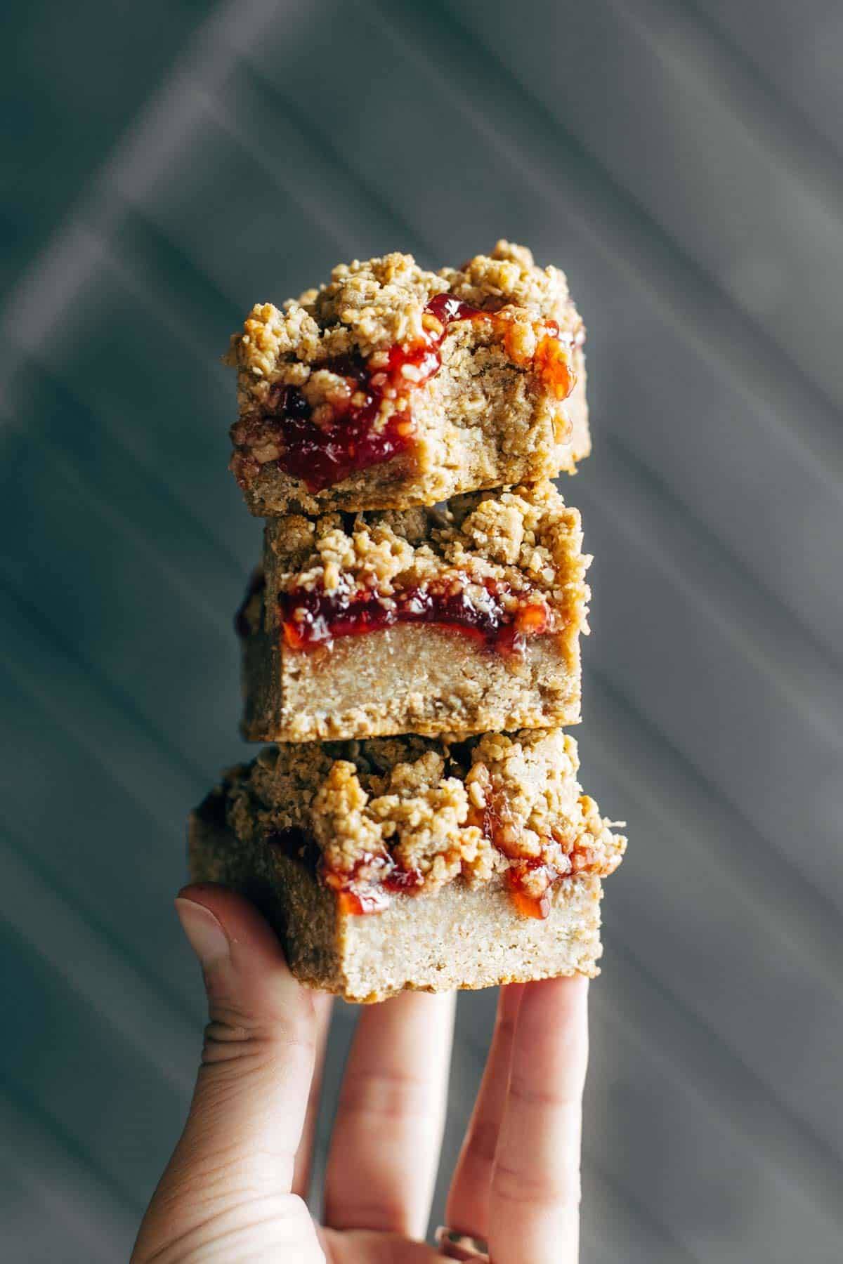 Hand holding three Strawberry Oat Crumble Bars 
